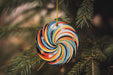 a colorful ornament hanging from a christmas tree