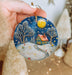 a person holding a christmas ornament in their hand
