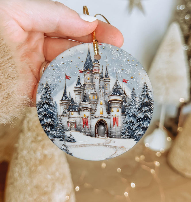 a hand holding a christmas ornament with a castle on it