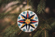 a ceramic ornament hanging from a christmas tree