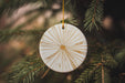 a white ornament hanging from a christmas tree