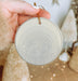 a person holding a round ornament in their hand