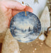 a person holding a christmas ornament in their hand
