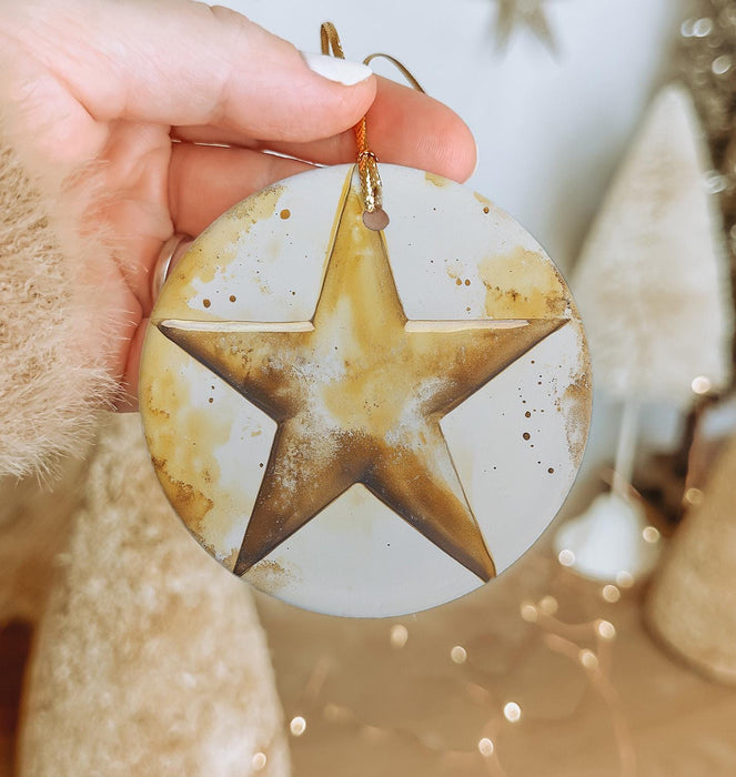 a person holding a christmas ornament with a star on it
