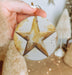 a person holding a christmas ornament with a star on it