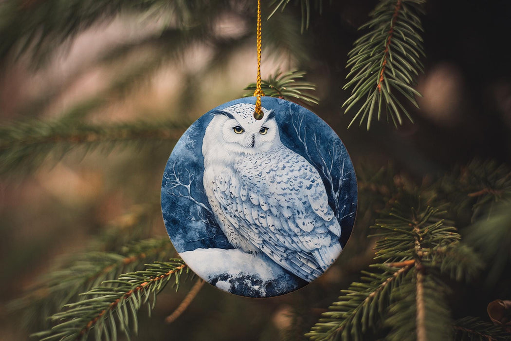 a ceramic owl ornament hanging from a pine tree