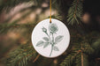 a white ornament hanging from a christmas tree