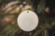 a white ornament hanging from a christmas tree