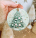 a person holding a christmas ornament in their hand