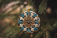 a blue and white ornament hanging from a tree