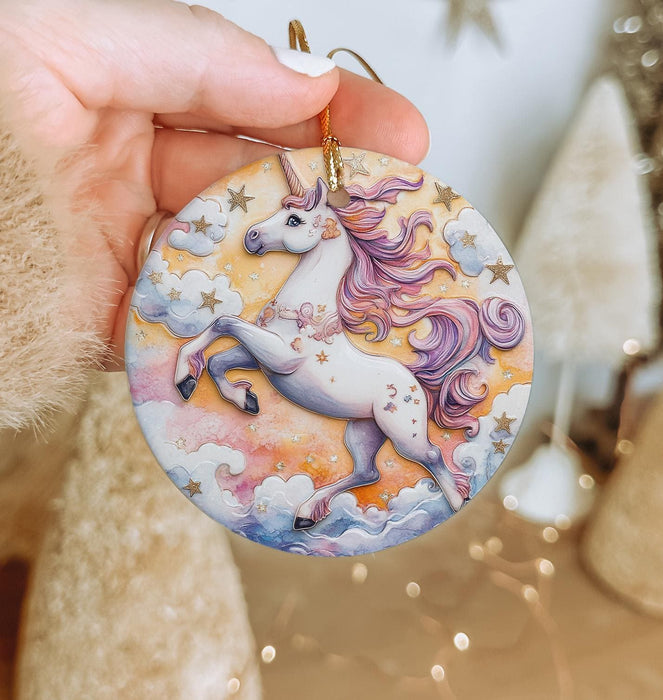 a hand holding a round ornament with a unicorn on it