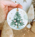 a person holding a christmas ornament in their hand