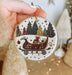 a person holding a christmas ornament in their hand