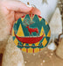 a person holding a christmas ornament in their hand