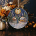 a christmas ornament with a snowy scene on it