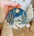 a person holding a christmas ornament in their hand
