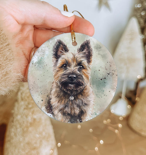 a hand holding a glass ornament with a picture of a dog