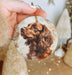 a hand holding a christmas ornament with a picture of a dog