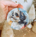 a person holding a dog ornament in their hand