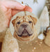 a person holding a dog ornament in their hand