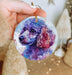a hand holding a purple poodle ornament
