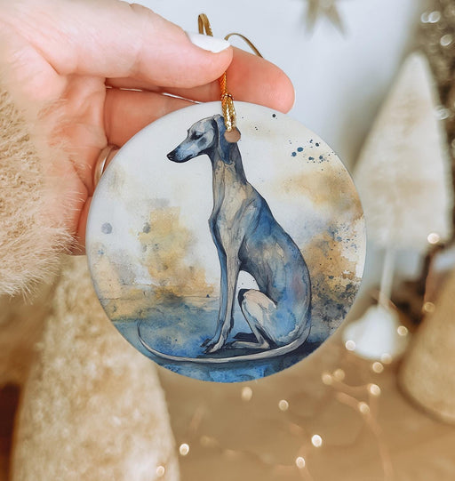 a hand holding a ceramic ornament with a dog on it