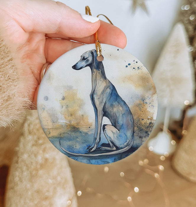 a hand holding a ceramic ornament with a dog on it