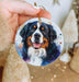 a hand holding a christmas ornament with a picture of a dog