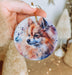 a person holding a dog ornament in their hand