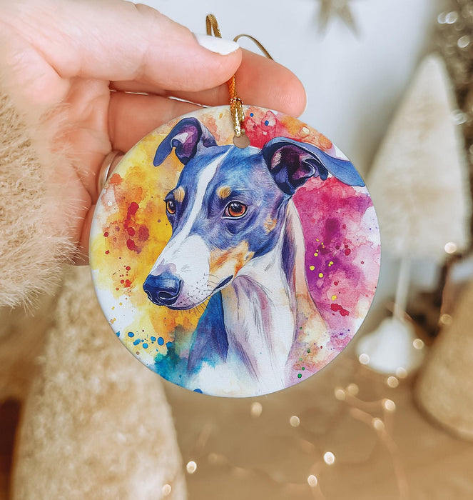 a hand holding a round ornament with a dog's face painted on