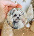a person holding a dog ornament in their hand