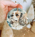 a person holding a dog ornament in their hand