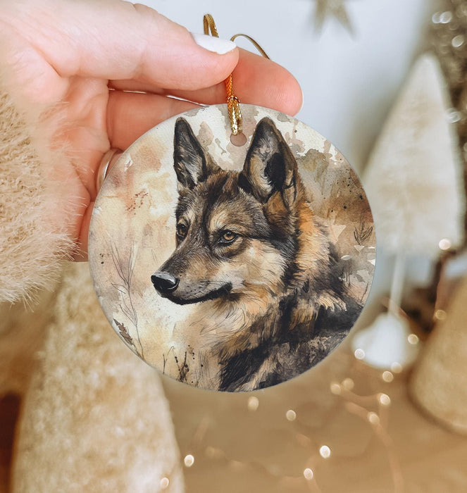 a hand holding a round ornament with a picture of a wolf on it