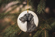 a black dog ornament hanging from a christmas tree