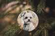 a white dog ornament hanging from a christmas tree