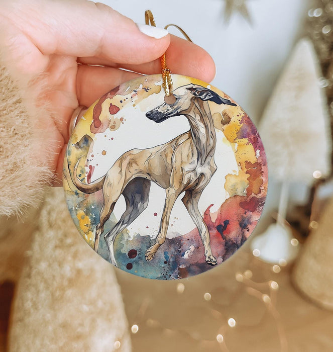 a hand holding a round ornament with a dog on it