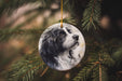 a black and white dog ornament hanging from a christmas tree