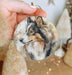 a person holding a dog ornament in their hand