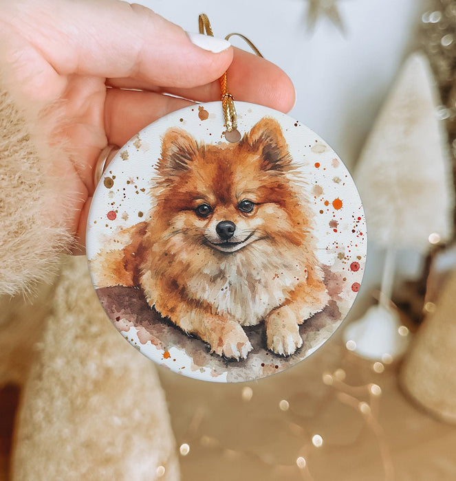 a person holding a christmas ornament with a small dog on it