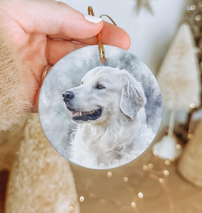 a hand holding a round ornament with a picture of a dog