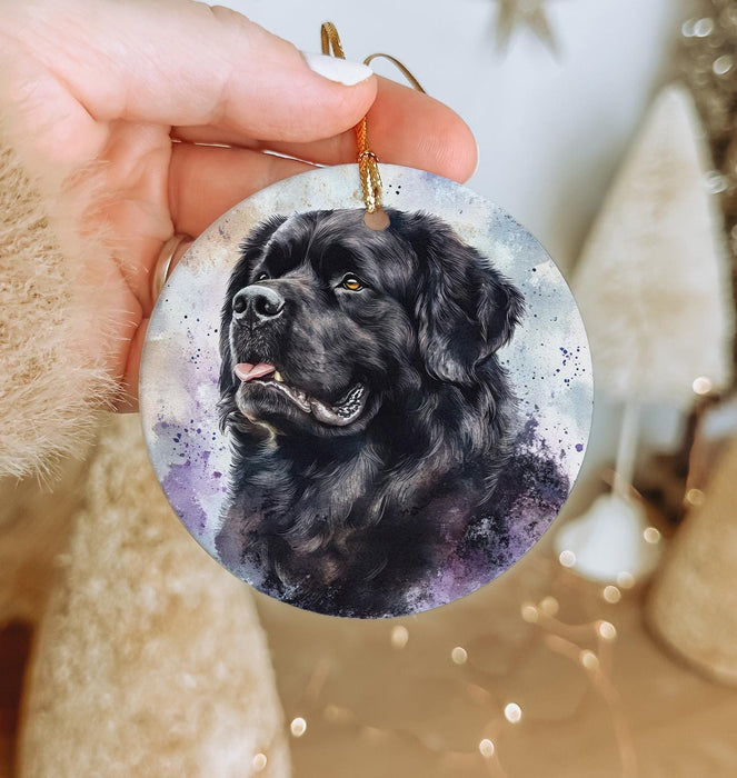 a hand holding a round ornament with a black dog on it