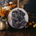 a picture of a black dog on a round ornament