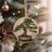 a ceramic ornament hanging from a christmas tree