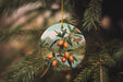 a glass ornament hanging from a pine tree