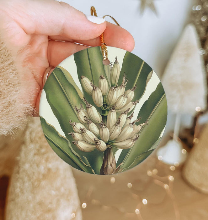 a hand holding a christmas ornament with a picture of a bunch of flowers