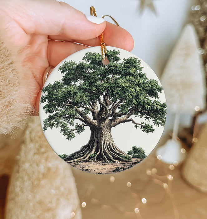 a person holding a christmas ornament with a tree on it
