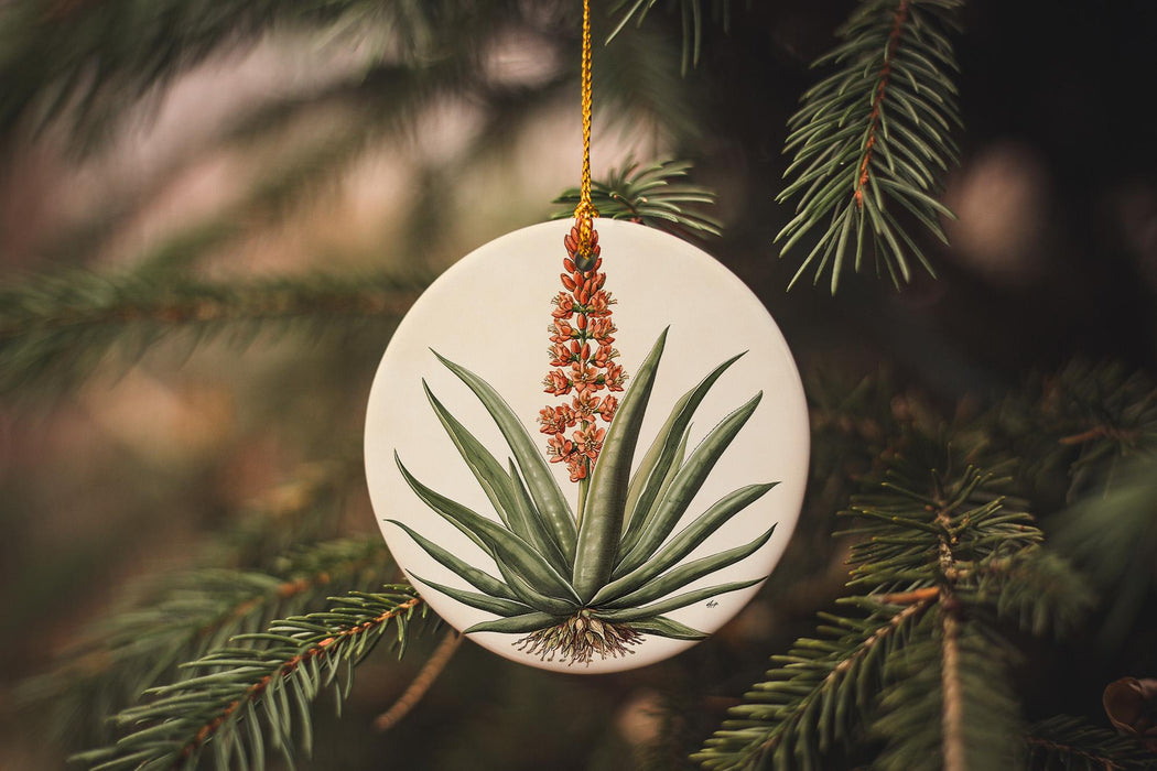 a white ornament with a plant on it
