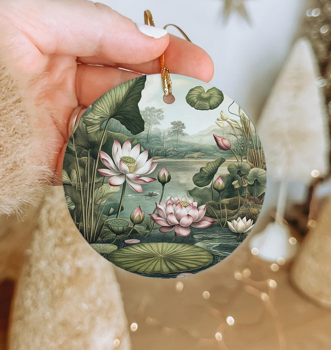 a person holding a round ornament with a painting of flowers