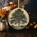 a ceramic ornament with a picture of a tree on it