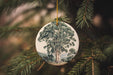 a ceramic ornament hanging from a christmas tree